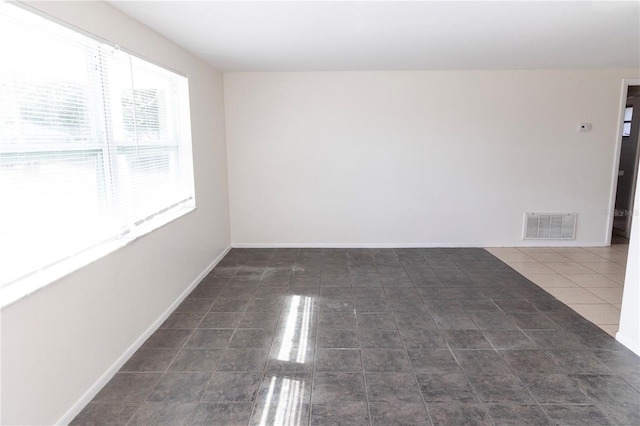 empty room featuring dark tile patterned floors