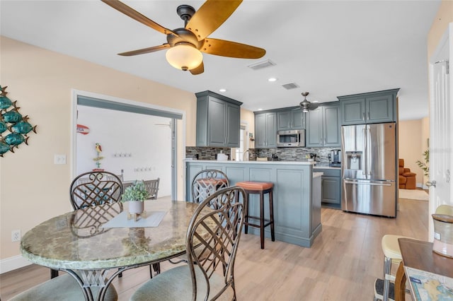 dining room with ceiling fan and light hardwood / wood-style flooring