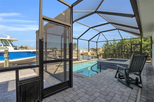 view of swimming pool with an in ground hot tub, a patio area, and a lanai