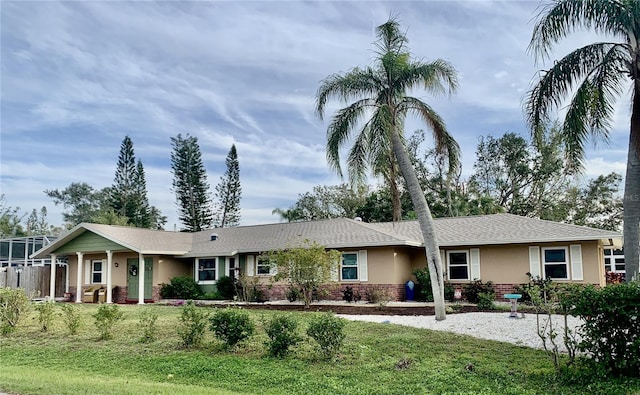 single story home featuring a front lawn and stucco siding