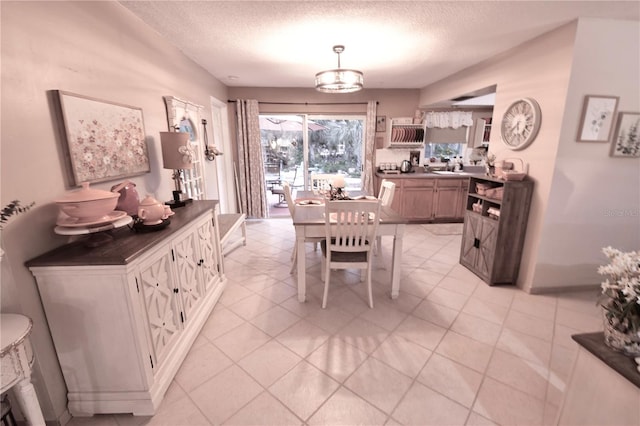 dining area featuring a textured ceiling and light tile patterned flooring