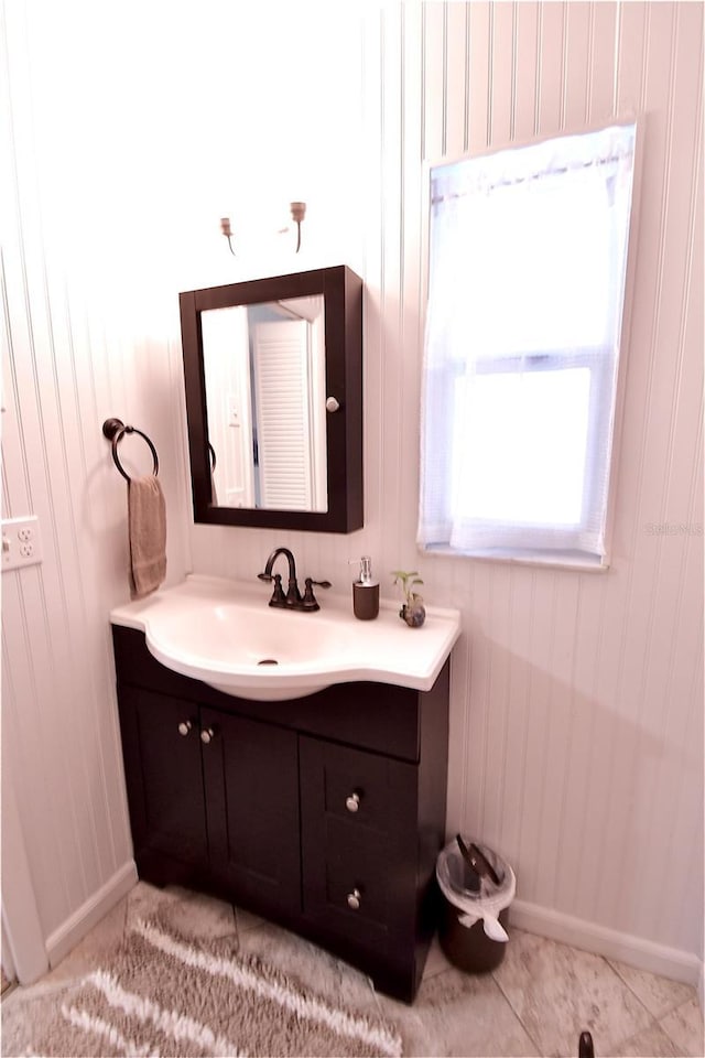 bathroom with baseboards, vanity, and tile patterned flooring