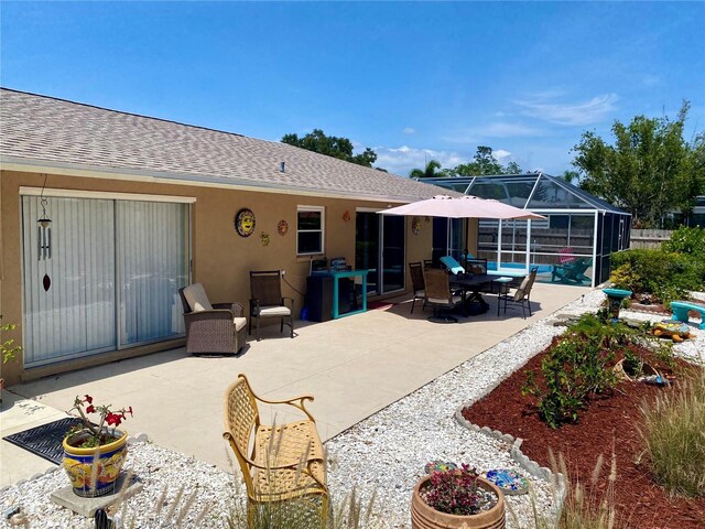 2426 Nassau St, Sarasota, FL 34231 - back of property with a patio area, a shingled roof, stucco siding, and a lanai