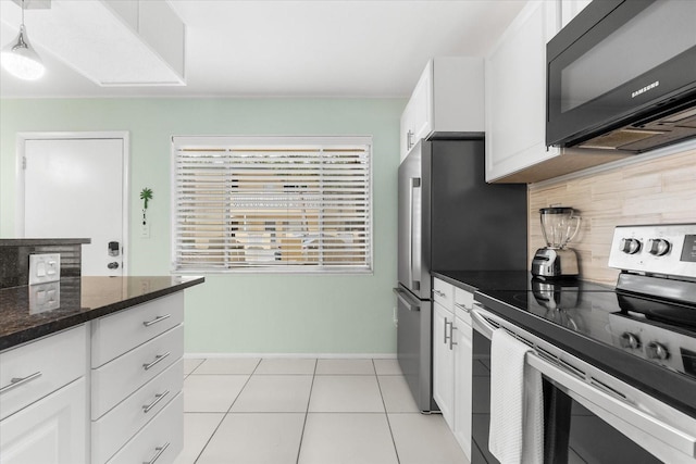 kitchen featuring decorative backsplash, dark stone counters, stainless steel electric stove, white cabinets, and light tile patterned flooring