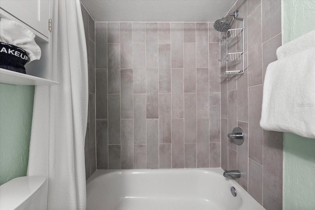 bathroom featuring shower / tub combo and toilet