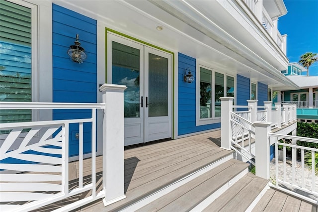 view of exterior entry featuring covered porch and french doors