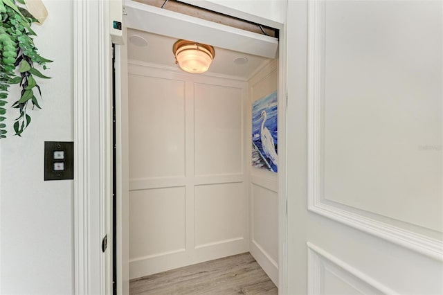 details with hardwood / wood-style flooring and elevator