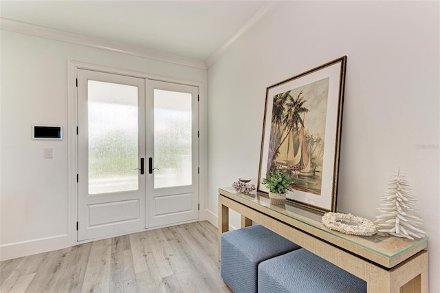 doorway with crown molding, light hardwood / wood-style flooring, and french doors