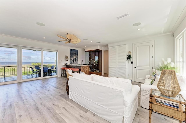 living room with ceiling fan, light hardwood / wood-style flooring, and ornamental molding