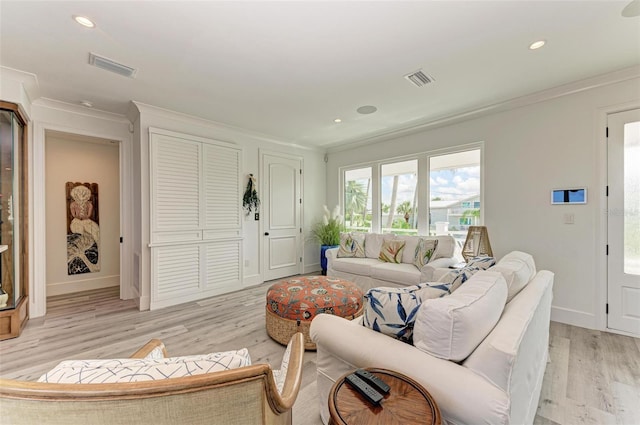 living room with light hardwood / wood-style flooring and ornamental molding