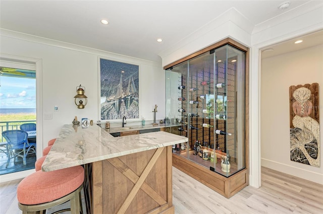 wine cellar featuring crown molding, light hardwood / wood-style flooring, and sink