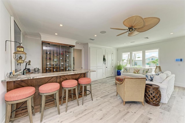 living room featuring ceiling fan, light hardwood / wood-style floors, and ornamental molding