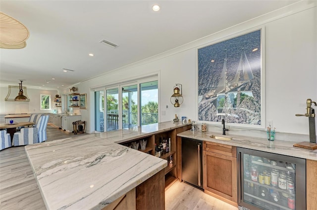 bar with light hardwood / wood-style floors, sink, crown molding, and beverage cooler