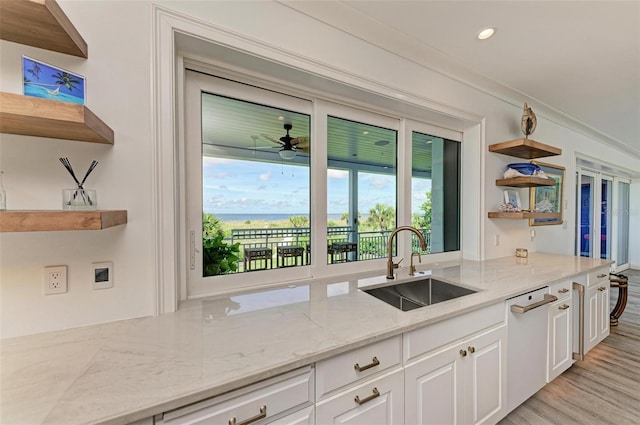 kitchen with white cabinetry, sink, dishwasher, and light stone counters