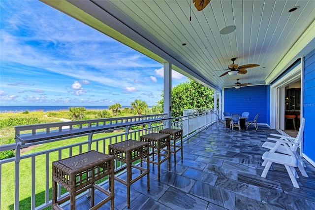 view of patio / terrace with a water view and a balcony