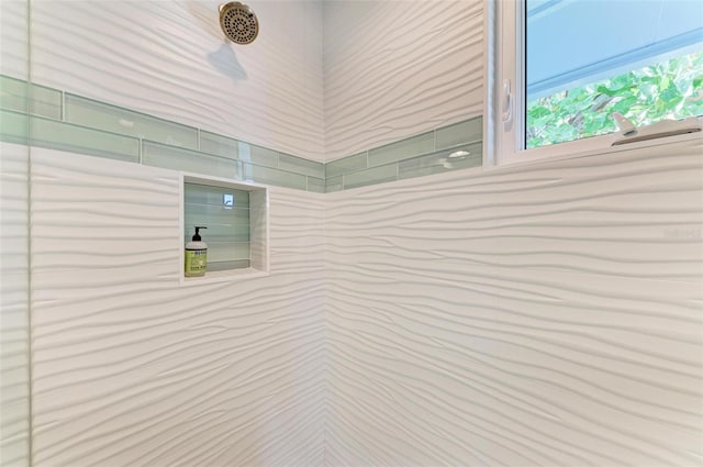 interior details featuring tiled shower