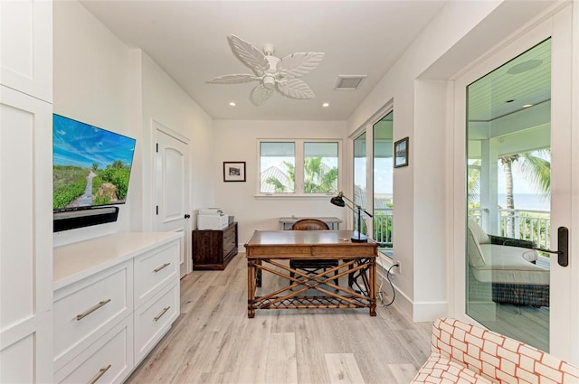 home office with light hardwood / wood-style floors and ceiling fan