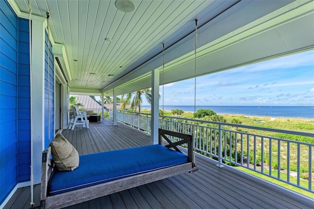 wooden terrace featuring covered porch and a water view