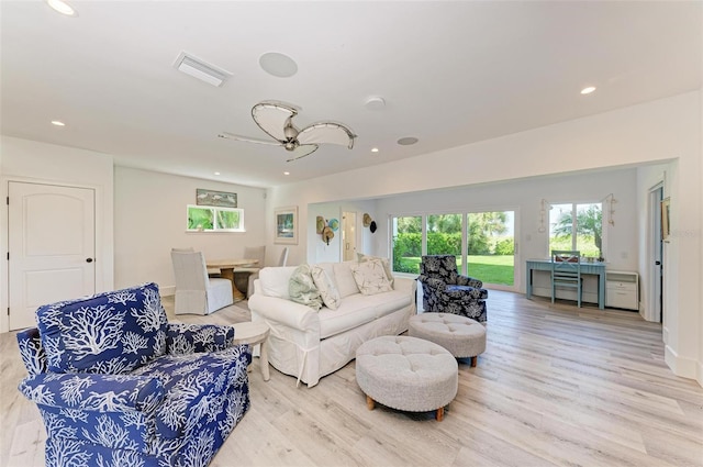 living room featuring light hardwood / wood-style flooring and ceiling fan