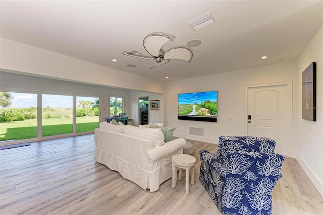 living room featuring ceiling fan and light hardwood / wood-style flooring