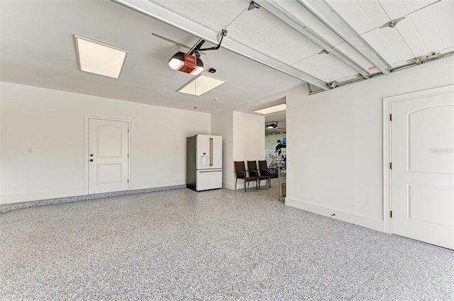 garage with white refrigerator with ice dispenser and a garage door opener