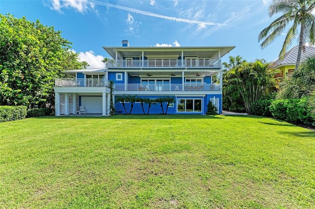 rear view of house featuring a yard, a balcony, and a garage