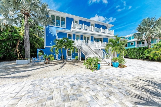 506 S Casey Key Rd, Nokomis, FL 34275 - raised beach house featuring a balcony, covered porch, and stairs