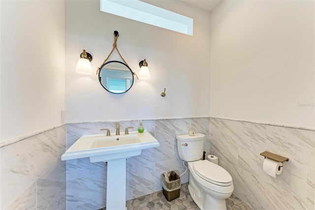 506 S Casey Key Rd, Nokomis, FL 34275 - half bath featuring toilet, tile walls, wainscoting, and a skylight