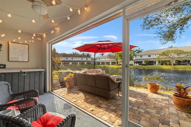 view of patio / terrace with a water view, ceiling fan, and outdoor lounge area