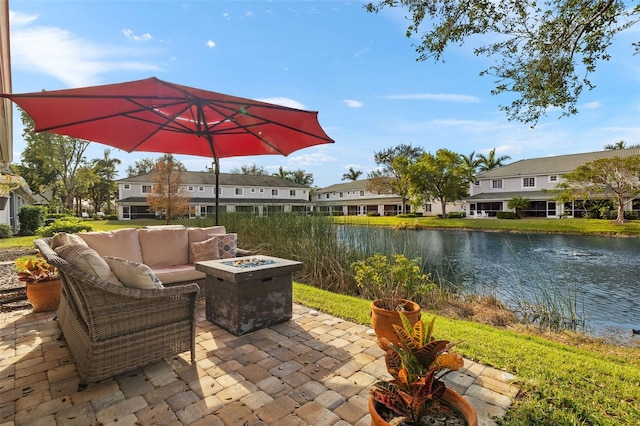 view of patio / terrace with an outdoor living space with a fire pit and a water view