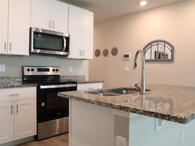 kitchen with dark stone counters, white cabinets, and stainless steel appliances