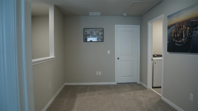 hallway with light carpet and washer / clothes dryer