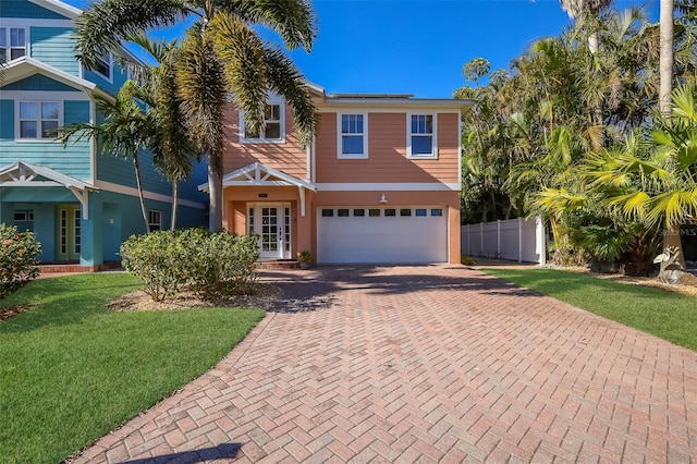 view of front of property with a garage, a front yard, and french doors