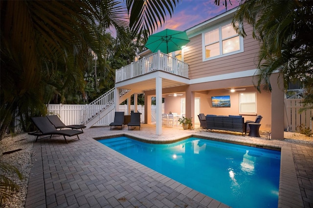 pool at dusk featuring outdoor lounge area and a patio