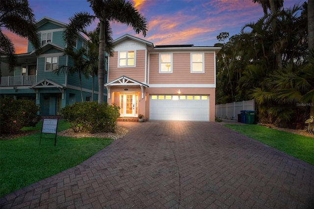 view of front of house featuring a garage, a yard, and french doors