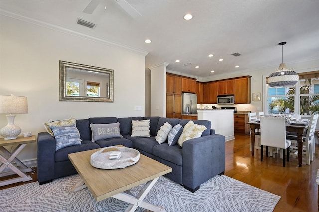 living room with hardwood / wood-style flooring, ceiling fan, and crown molding