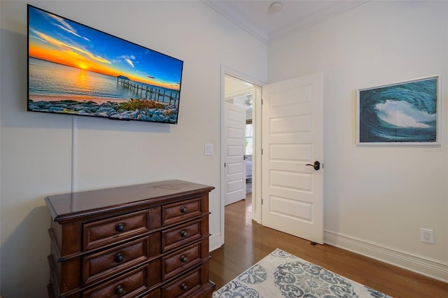 hallway with hardwood / wood-style floors and crown molding