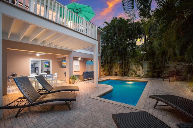 pool at dusk featuring a patio