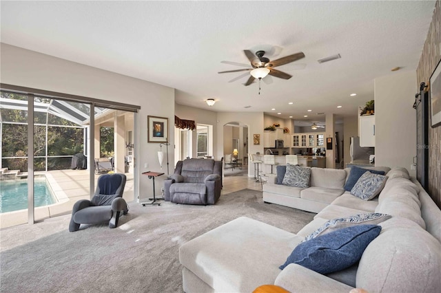 living room featuring light carpet and ceiling fan