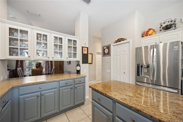 kitchen with white cabinets, stainless steel fridge, gray cabinets, and light tile patterned flooring