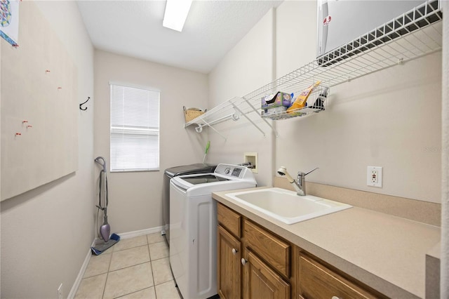 washroom with sink, light tile patterned flooring, and independent washer and dryer