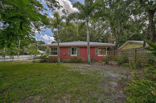 rear view of property featuring a lawn