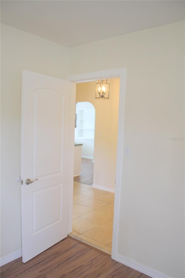 corridor with built in features and hardwood / wood-style floors