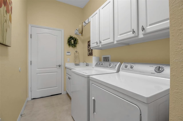 clothes washing area featuring cabinets, sink, and washing machine and clothes dryer