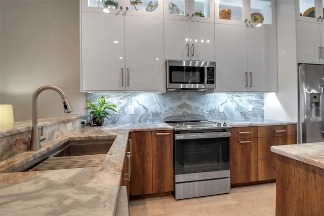 kitchen with sink, stainless steel appliances, white cabinetry, and backsplash