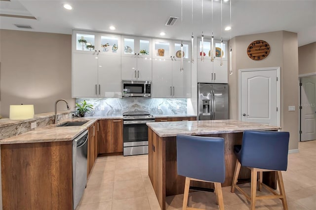 kitchen featuring sink, white cabinets, stainless steel appliances, and a center island