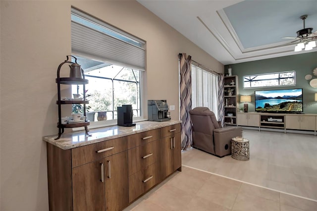 office area with ceiling fan and a tray ceiling