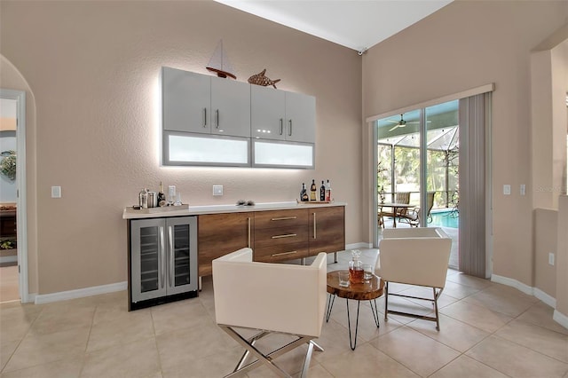 kitchen with white cabinetry, beverage cooler, and light tile patterned flooring