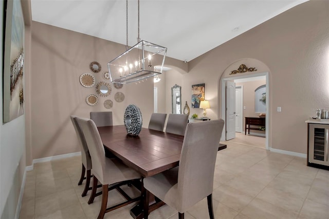 tiled dining room with wine cooler and lofted ceiling