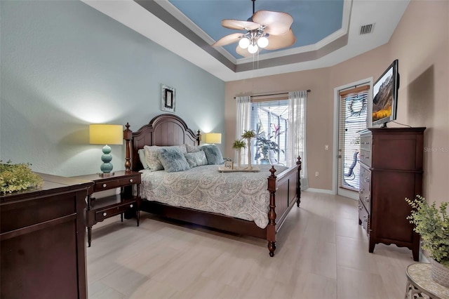 bedroom featuring access to exterior, crown molding, ceiling fan, and a raised ceiling